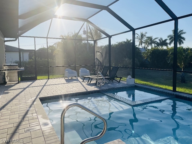 view of pool featuring glass enclosure, a grill, a patio area, and a jacuzzi