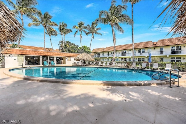 pool with a patio and fence