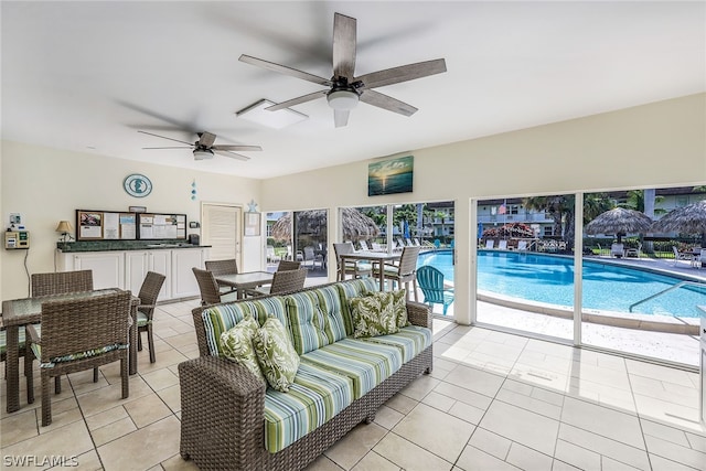 tiled living room featuring a healthy amount of sunlight and ceiling fan