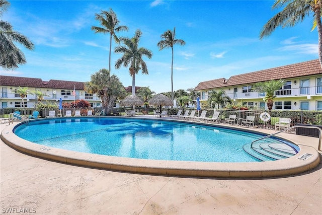 view of swimming pool with a residential view, a patio, and fence