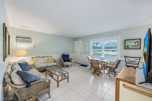 living area with light tile patterned floors, a wainscoted wall, and a wall mounted AC