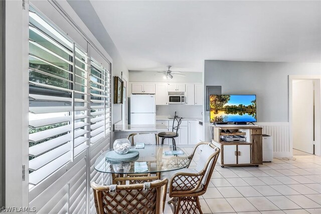 tiled dining room featuring ceiling fan