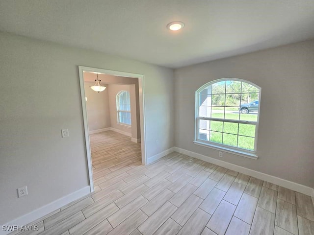 empty room with baseboards and wood tiled floor