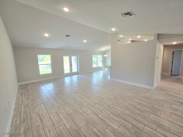 interior space with vaulted ceiling, visible vents, baseboards, and wood tiled floor