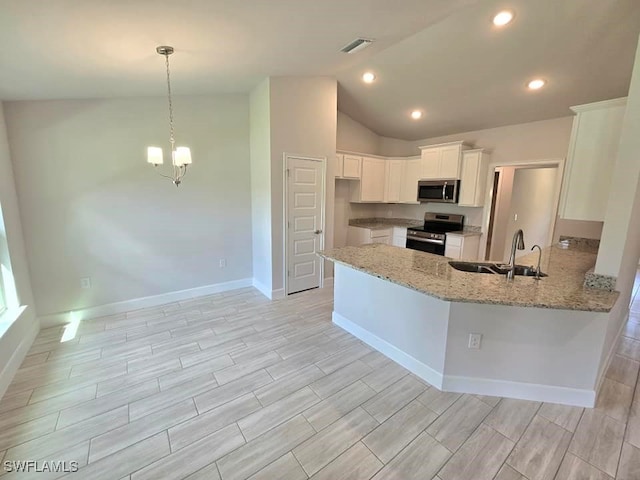 kitchen with light stone counters, visible vents, a peninsula, stainless steel appliances, and white cabinets