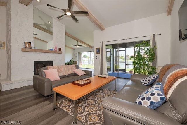 living room featuring vaulted ceiling with beams, a stone fireplace, dark hardwood / wood-style flooring, and ceiling fan