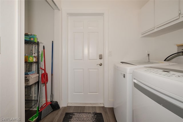 clothes washing area featuring independent washer and dryer, wood-type flooring, and cabinets