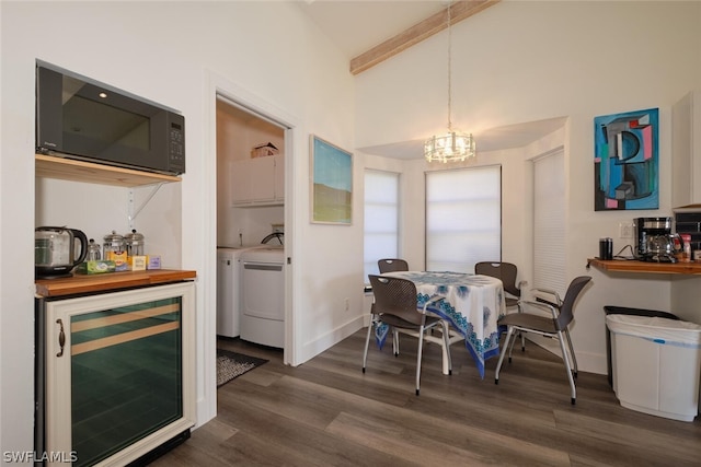 dining room featuring dark wood-type flooring, washing machine and dryer, beverage cooler, and lofted ceiling