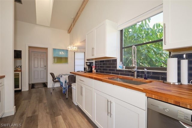 kitchen with dishwashing machine, wood-type flooring, butcher block countertops, and decorative backsplash