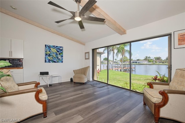 living area featuring dark hardwood / wood-style floors, a water view, ceiling fan, and vaulted ceiling with beams