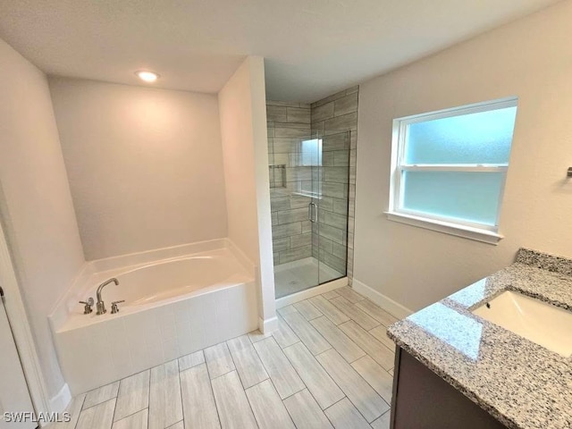 bathroom featuring plus walk in shower and vanity