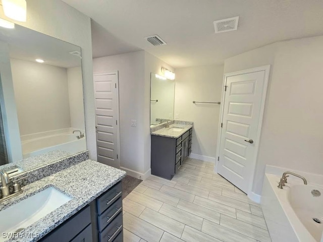 bathroom with vanity and a bath