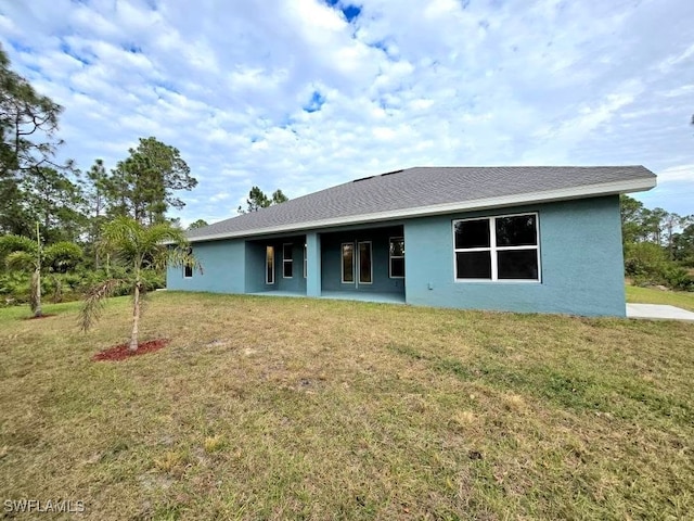 back of property featuring a lawn