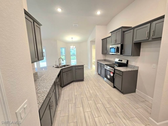 kitchen featuring light stone countertops, appliances with stainless steel finishes, kitchen peninsula, sink, and pendant lighting