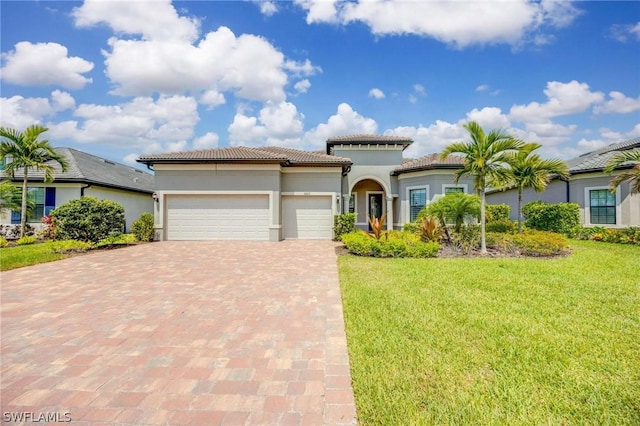 mediterranean / spanish house featuring a garage and a front yard