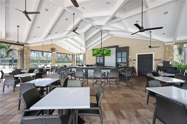 dining area with ceiling fan, beamed ceiling, and high vaulted ceiling