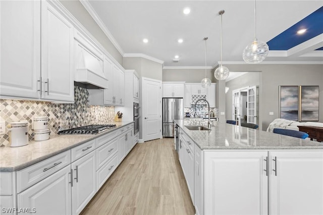 kitchen with white cabinets, a large island, sink, and stainless steel appliances