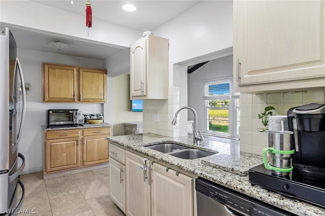 kitchen featuring light stone countertops, tasteful backsplash, stainless steel appliances, light tile flooring, and sink