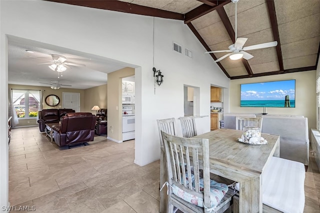 dining room featuring ceiling fan, beam ceiling, high vaulted ceiling, and light tile floors