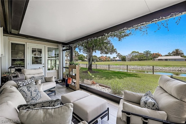 sunroom featuring a water view