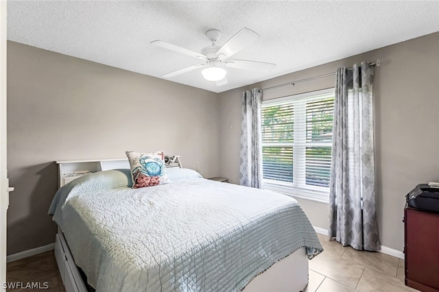 bedroom featuring a textured ceiling, ceiling fan, and light tile floors