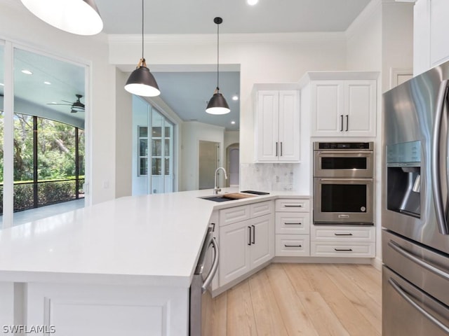 kitchen featuring ceiling fan, sink, decorative backsplash, white cabinets, and appliances with stainless steel finishes