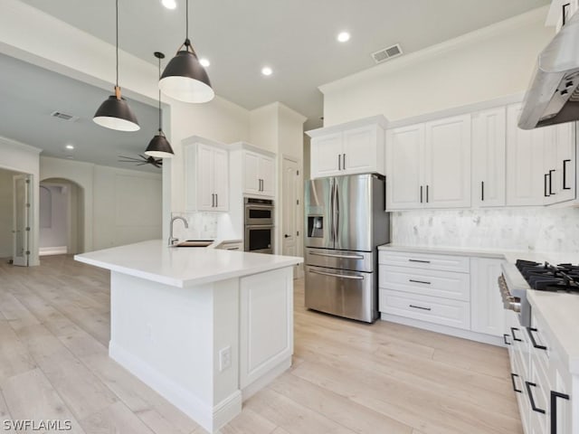 kitchen featuring sink, backsplash, decorative light fixtures, white cabinets, and appliances with stainless steel finishes