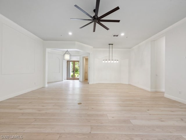 empty room with french doors, light hardwood / wood-style floors, ceiling fan, and ornamental molding