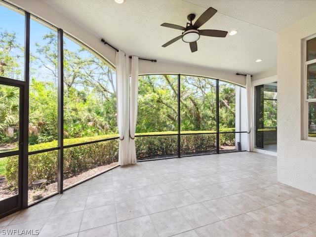 unfurnished sunroom with ceiling fan