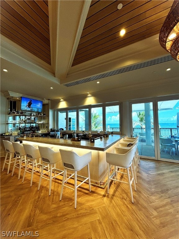 bar with light parquet floors and crown molding