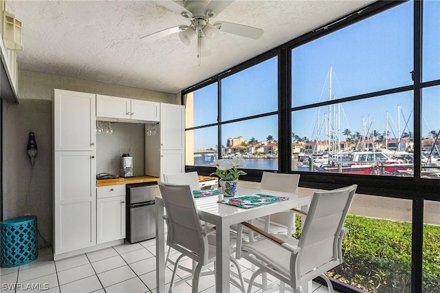 interior space featuring a wealth of natural light, a water view, and ceiling fan