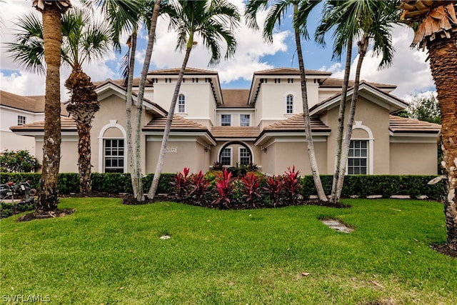 mediterranean / spanish house featuring a front yard