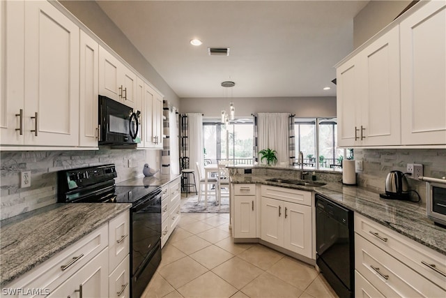 kitchen featuring light stone counters, white cabinetry, black appliances, sink, and light tile floors