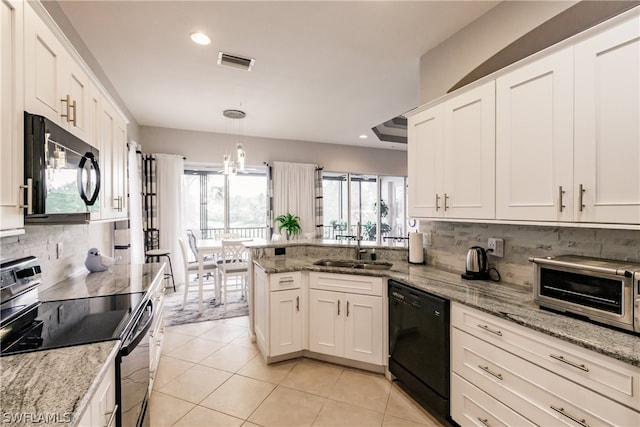 kitchen featuring a healthy amount of sunlight, sink, black appliances, and tasteful backsplash