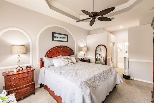 carpeted bedroom featuring ceiling fan, ornamental molding, connected bathroom, and a raised ceiling