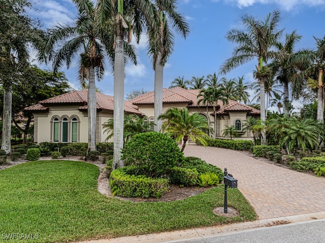 mediterranean / spanish-style house featuring a front yard