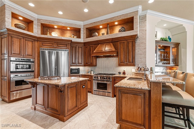 kitchen with kitchen peninsula, ornamental molding, custom range hood, premium appliances, and sink