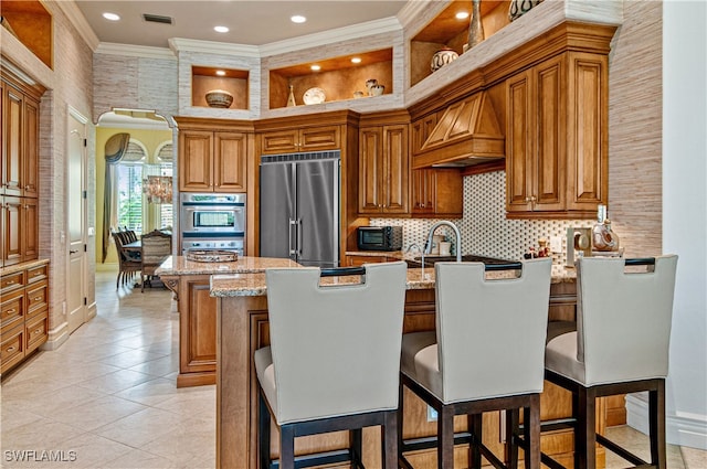 kitchen featuring crown molding, a kitchen island, light stone counters, and appliances with stainless steel finishes