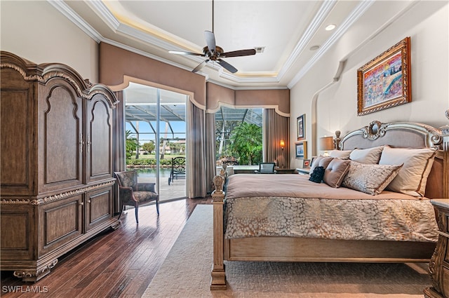 bedroom with a raised ceiling, dark hardwood / wood-style floors, ceiling fan, and access to exterior