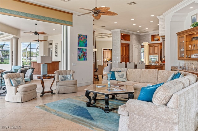 living room with light tile patterned floors, ornate columns, and ornamental molding