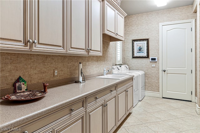 laundry room with washer and clothes dryer, light tile patterned flooring, cabinets, and sink