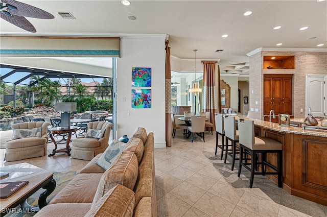 living room with ceiling fan and ornamental molding