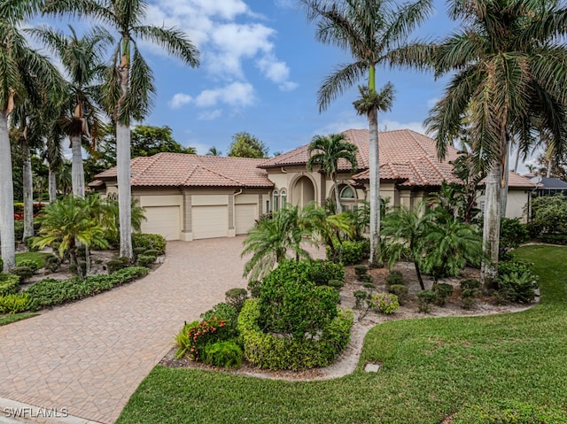 mediterranean / spanish home with a front lawn and a garage