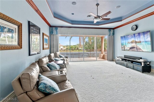 carpeted living room with crown molding, a raised ceiling, and ceiling fan