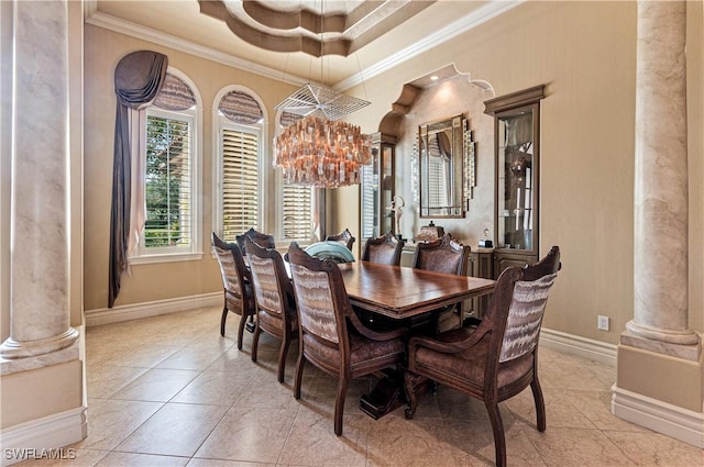 dining room featuring decorative columns, ornamental molding, light tile patterned floors, a notable chandelier, and a tray ceiling