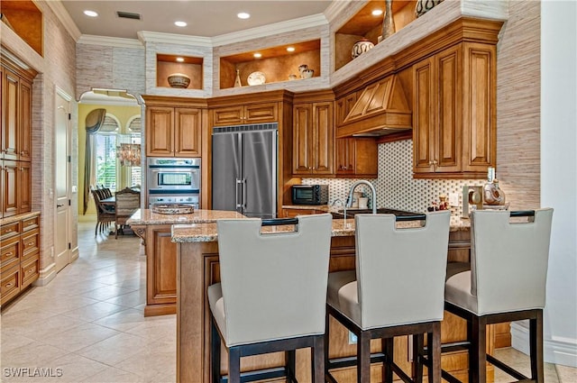 kitchen with stainless steel appliances, premium range hood, a center island, and light stone counters