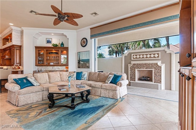 living room with ornamental molding, light tile patterned floors, a tile fireplace, and plenty of natural light