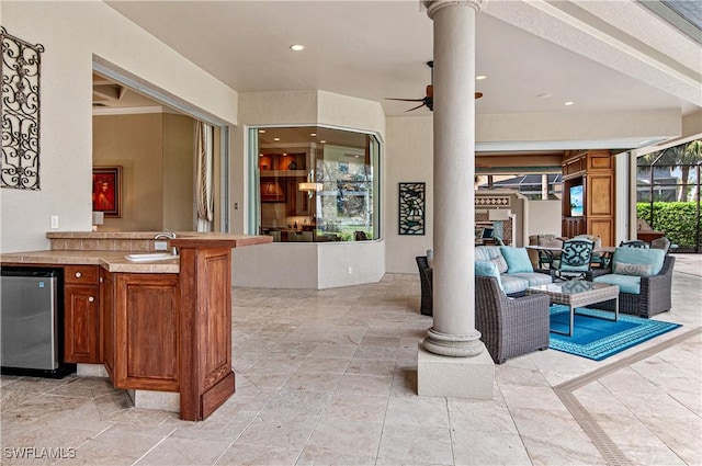 view of patio with ceiling fan, an outdoor living space, and a wet bar