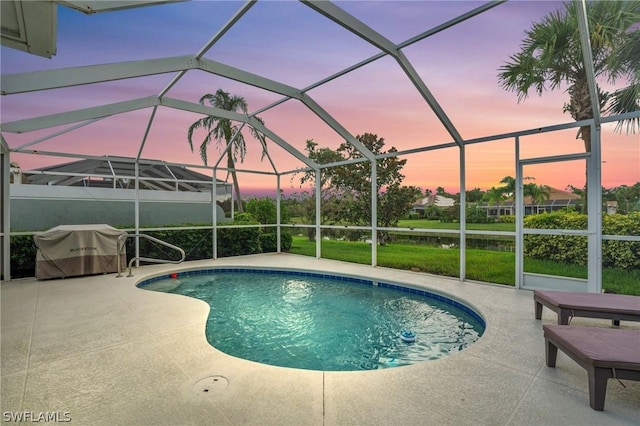 pool at dusk featuring a patio area and glass enclosure