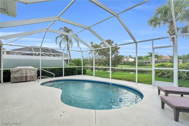 view of swimming pool with glass enclosure, a patio area, and a lawn